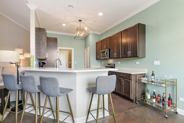 4100 Coyote Lakes Cir, Lake In The Hills, IL 60156 - kitchen featuring stainless steel microwave, a breakfast bar area, ornamental molding, dark wood-type flooring, and light countertops
