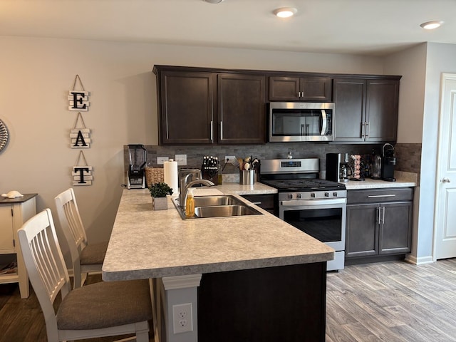 582 Spring Leaf Dr, Joliet, IL 60431 - kitchen featuring stainless steel appliances, light countertops, light wood-style floors, dark brown cabinetry, and tasteful backsplash