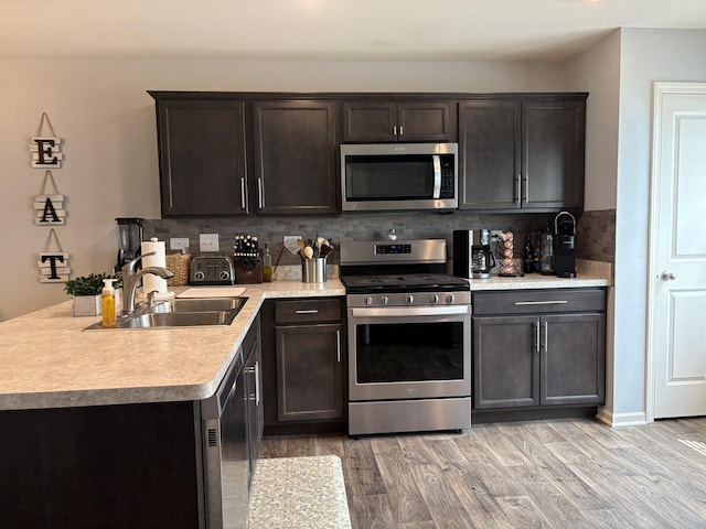 582 Spring Leaf Dr, Joliet, IL 60431 - kitchen featuring appliances with stainless steel finishes, light countertops, tasteful backsplash, light wood-style floors, and dark brown cabinets