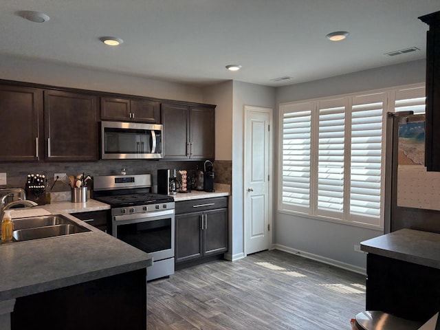 582 Spring Leaf Dr, Joliet, IL 60431 - kitchen featuring stainless steel appliances, dark brown cabinets, tasteful backsplash, wood finished floors, and recessed lighting
