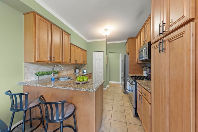 931 Mesa Dr, Elgin, IL 60123 - kitchen featuring appliances with stainless steel finishes, tasteful backsplash, light stone countertops, a peninsula, and ornamental molding