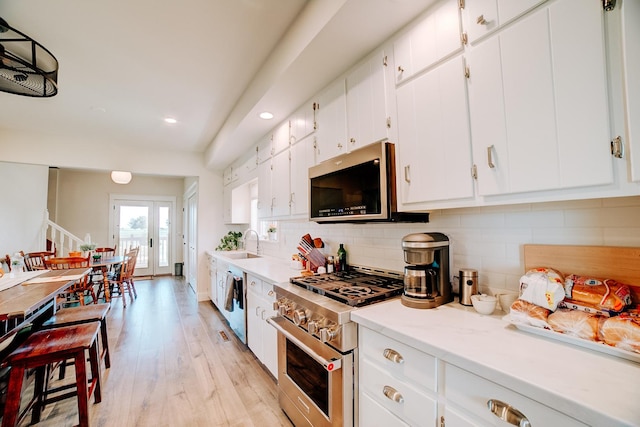 1533 E 1400 N Rd, Crescent City, IL 60928 - kitchen featuring appliances with stainless steel finishes, decorative backsplash, light wood-style flooring, recessed lighting, and white cabinetry