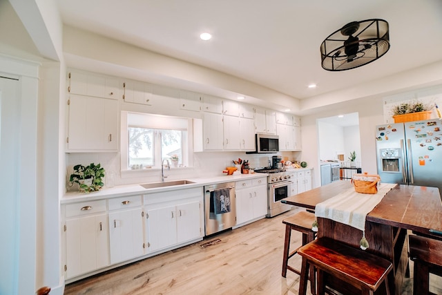 1533 E 1400 N Rd, Crescent City, IL 60928 - kitchen featuring stainless steel appliances, separate washer and dryer, light wood-style flooring, light countertops, and white cabinetry