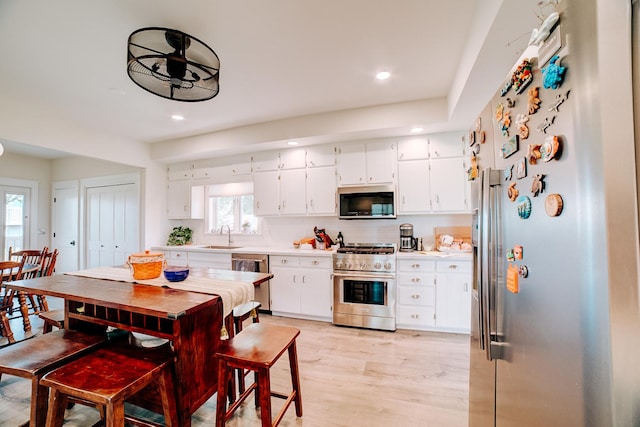1533 E 1400 N Rd, Crescent City, IL 60928 - kitchen featuring stainless steel appliances, recessed lighting, light countertops, white cabinets, and light wood-style flooring