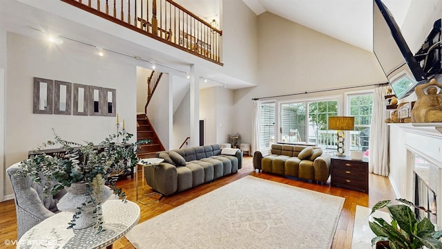 0N488 Baker Dr, Geneva, IL 60134 - living room with track lighting, a premium fireplace, wood finished floors, stairs, and high vaulted ceiling
