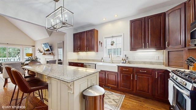 0N488 Baker Dr, Geneva, IL 60134 - kitchen with appliances with stainless steel finishes, a chandelier, light wood-style floors, light stone counters, and backsplash