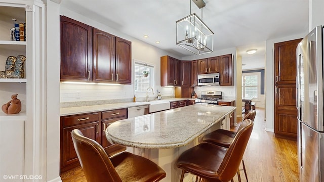 0N488 Baker Dr, Geneva, IL 60134 - kitchen with appliances with stainless steel finishes, healthy amount of natural light, a kitchen bar, light wood-style flooring, and recessed lighting