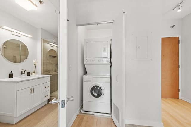 330 W Grand Ave Unit 1307, Chicago, IL 60654 - washroom featuring stacked washing machine and dryer, light wood-style floors, and electric panel