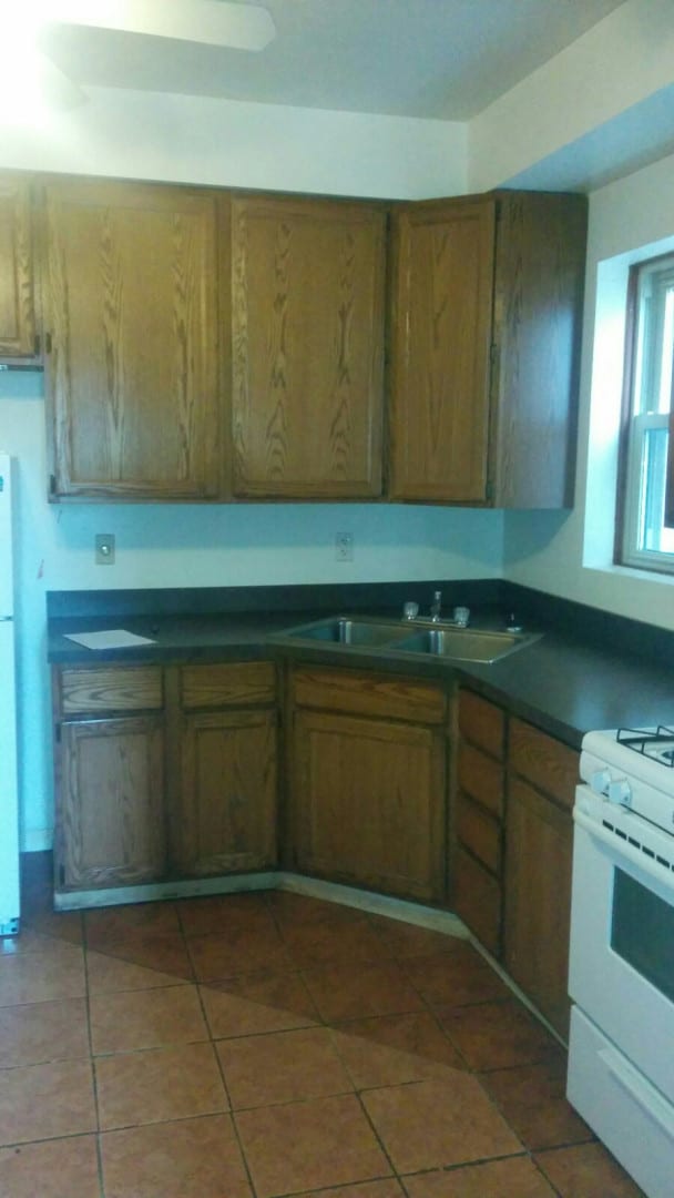 2244 W Augusta Blvd, Chicago, IL 60622 - kitchen featuring white appliances, dark countertops, light tile patterned flooring, and brown cabinets
