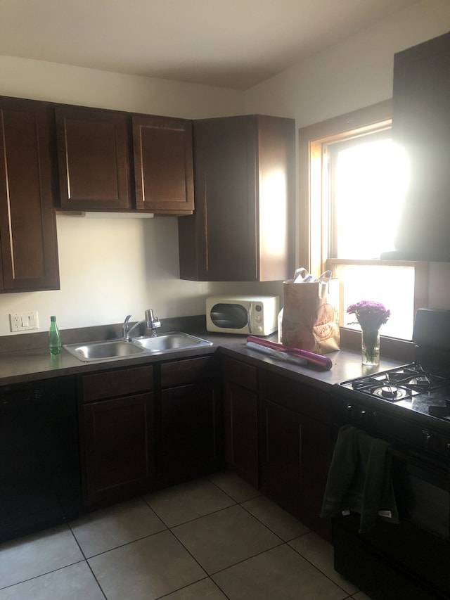 2244 W Augusta Blvd, Chicago, IL 60622 - kitchen with black gas stove, light tile patterned floors, dark brown cabinetry, and dark countertops