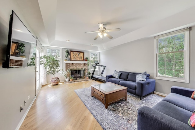 2114 Birchwood Ln, Buffalo Grove, IL 60089 - living area featuring a brick fireplace, a raised ceiling, plenty of natural light, and wood finished floors