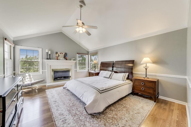 2114 Birchwood Ln, Buffalo Grove, IL 60089 - bedroom with wood finished floors, vaulted ceiling, a fireplace with raised hearth, a ceiling fan, and crown molding