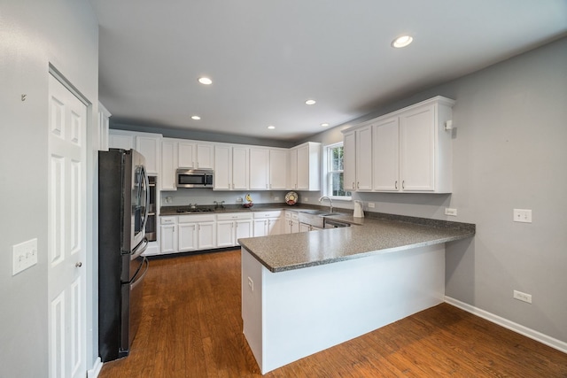 1616 Sutton Pl, Bolingbrook, IL 60490 - kitchen with appliances with stainless steel finishes, a peninsula, white cabinets, dark wood finished floors, and dark countertops