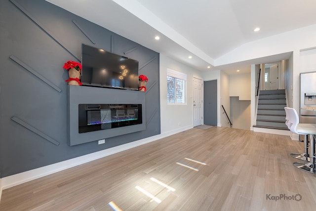 9130 S Greenwood Ave, Chicago, IL 60619 - unfurnished living room with lofted ceiling, light wood-type flooring, recessed lighting, a glass covered fireplace, and stairs