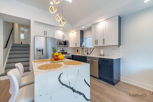 9130 S Greenwood Ave, Chicago, IL 60619 - kitchen with stainless steel appliances, decorative backsplash, light stone counters, light wood finished floors, and vaulted ceiling
