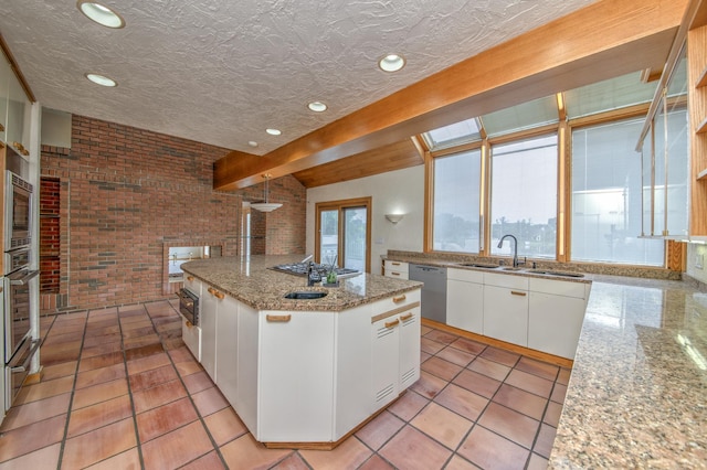 8170 Lake Ridge Dr, Burr Ridge, IL 60527 - kitchen with brick wall, appliances with stainless steel finishes, a center island with sink, white cabinets, and recessed lighting
