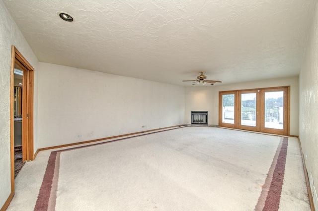 8170 Lake Ridge Dr, Burr Ridge, IL 60527 - unfurnished living room with light carpet, a ceiling fan, a fireplace with raised hearth, and a textured ceiling