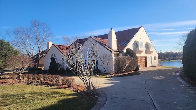 8170 Lake Ridge Dr, Burr Ridge, IL 60527 - view of side of property featuring concrete driveway, a chimney, stucco siding, a garage, and a yard