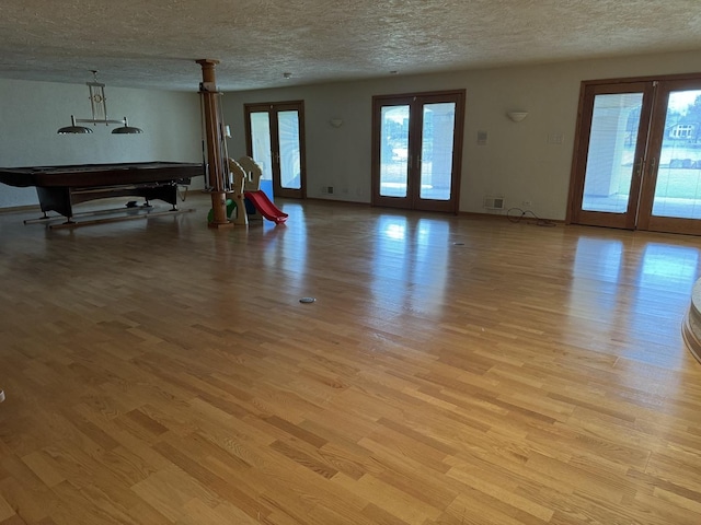 8170 Lake Ridge Dr, Burr Ridge, IL 60527 - living area with light wood-style floors, a textured ceiling, healthy amount of natural light, and french doors