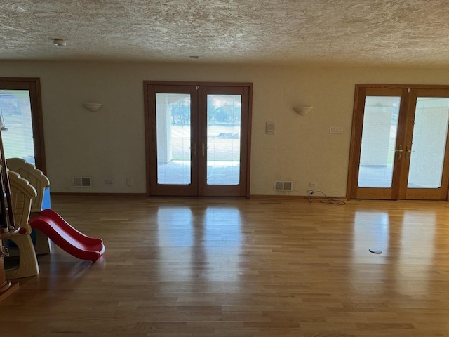 8170 Lake Ridge Dr, Burr Ridge, IL 60527 - empty room featuring french doors, a textured ceiling, and wood finished floors