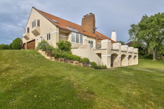 8170 Lake Ridge Dr, Burr Ridge, IL 60527 - back of house featuring stucco siding, a chimney, a lawn, and a balcony