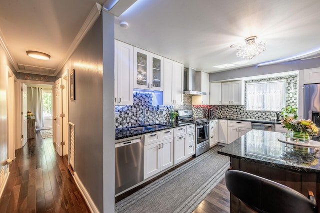 484 Valleyview Dr, Bartlett, IL 60103 - kitchen with stainless steel appliances, wall chimney range hood, crown molding, dark stone countertops, and white cabinetry