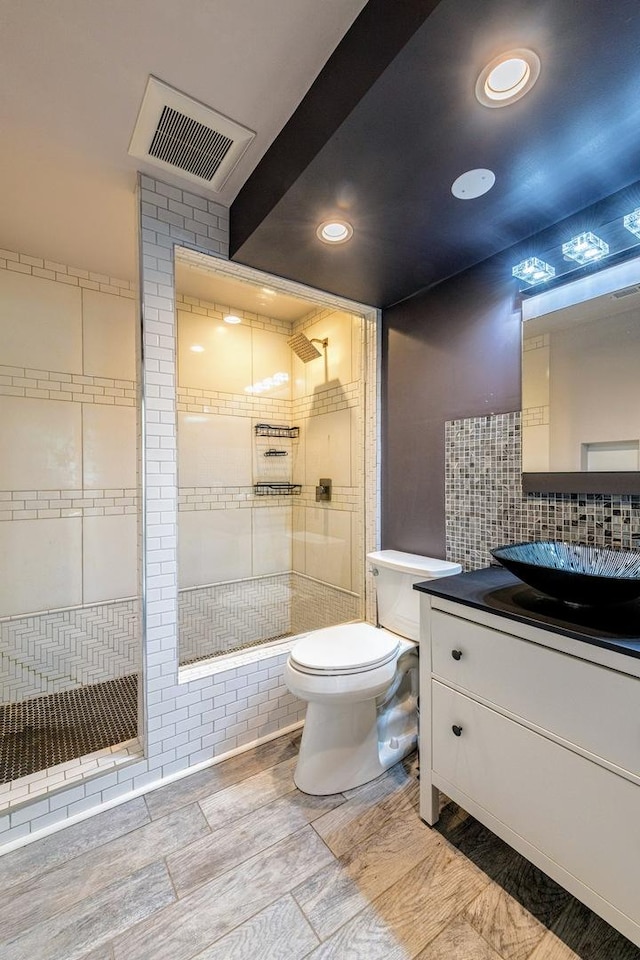 484 Valleyview Dr, Bartlett, IL 60103 - bathroom featuring a tile shower, vanity, recessed lighting, and decorative backsplash