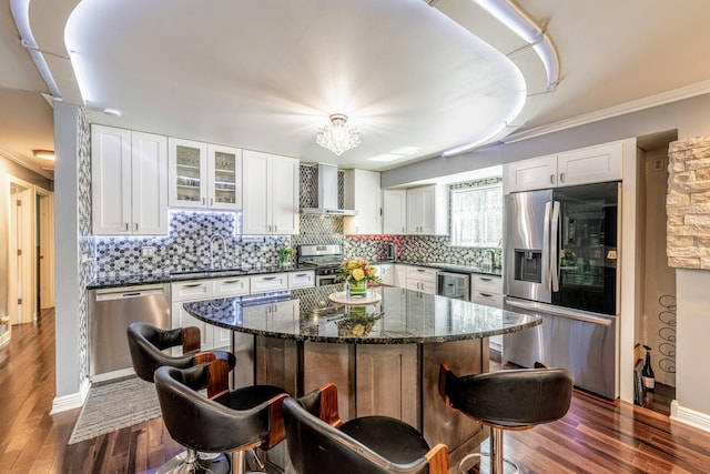 484 Valleyview Dr, Bartlett, IL 60103 - kitchen featuring appliances with stainless steel finishes, wall chimney exhaust hood, a kitchen breakfast bar, white cabinetry, and ornamental molding
