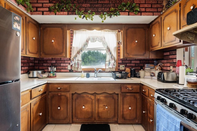 6650 Happy Acres Rd, Rockford, IL 61101 - kitchen featuring appliances with stainless steel finishes, light countertops, light tile patterned floors, and brown cabinets