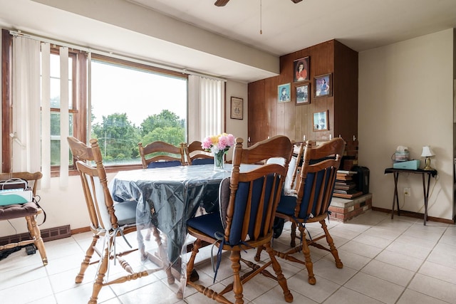 6650 Happy Acres Rd, Rockford, IL 61101 - dining room featuring wooden walls, a ceiling fan, light tile patterned floors, and an accent wall