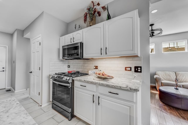18422 Century Ct, Tinley Park, IL 60477 - kitchen with stainless steel appliances, white cabinetry, backsplash, light stone counters, and open floor plan