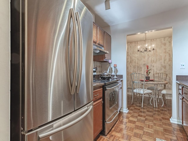 2300 Windsor Mall Unit 2G, Park Ridge, IL 60068 - kitchen featuring appliances with stainless steel finishes, brown cabinets, under cabinet range hood, a chandelier, and hanging light fixtures
