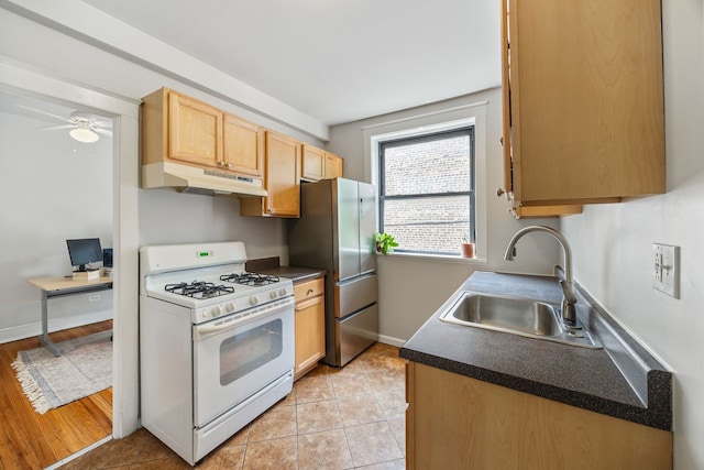 4753 N Talman St Unit 2S, Chicago, IL 60625 - kitchen featuring white gas range oven, under cabinet range hood, freestanding refrigerator, dark countertops, and ceiling fan