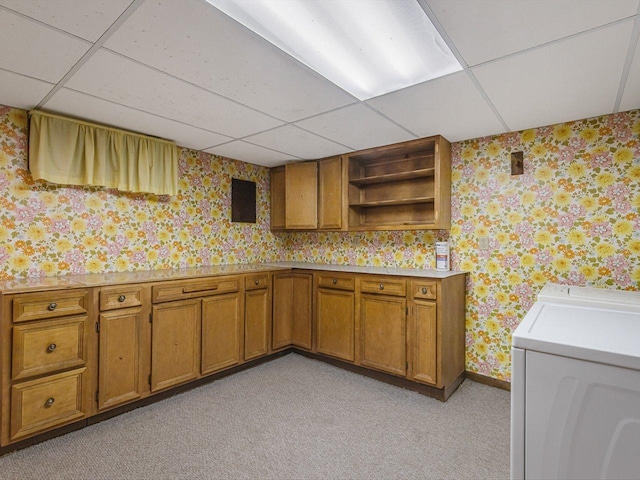 409 Lynne Ln, Belvidere, IL 61008 - kitchen with wallpapered walls, brown cabinetry, a drop ceiling, washing machine and dryer, and open shelves