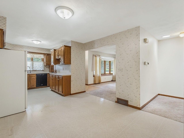 409 Lynne Ln, Belvidere, IL 61008 - kitchen with freestanding refrigerator, dishwasher, brown cabinetry, plenty of natural light, and wallpapered walls