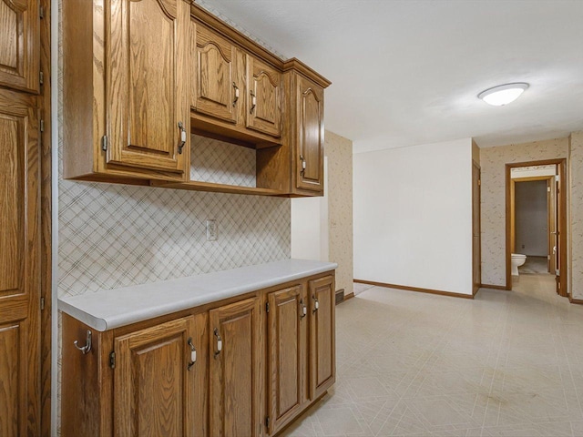 409 Lynne Ln, Belvidere, IL 61008 - kitchen with tasteful backsplash, light countertops, and brown cabinetry
