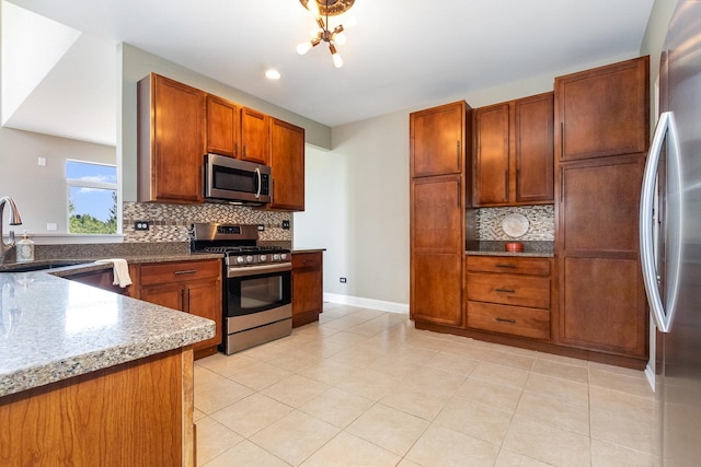 1617 Fieldstone Dr S Unit 13-1, Shorewood, IL 60404 - kitchen with appliances with stainless steel finishes, decorative backsplash, light tile patterned floors, brown cabinetry, and light stone counters
