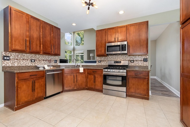1617 Fieldstone Dr S Unit 13-1, Shorewood, IL 60404 - kitchen with appliances with stainless steel finishes, decorative backsplash, recessed lighting, light tile patterned floors, and brown cabinetry