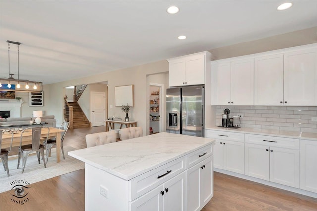 23008 Anna Ln, Frankfort, IL 60423 - kitchen featuring stainless steel fridge with ice dispenser, open floor plan, tasteful backsplash, light wood-style flooring, and decorative light fixtures