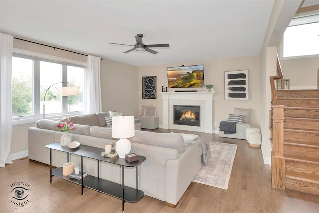 23008 Anna Ln, Frankfort, IL 60423 - living room featuring ceiling fan, a tile fireplace, wood finished floors, and stairs