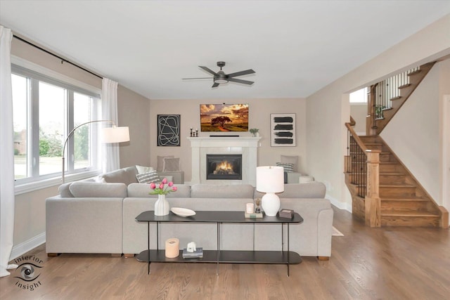 23008 Anna Ln, Frankfort, IL 60423 - living room featuring ceiling fan, stairs, a glass covered fireplace, and wood finished floors