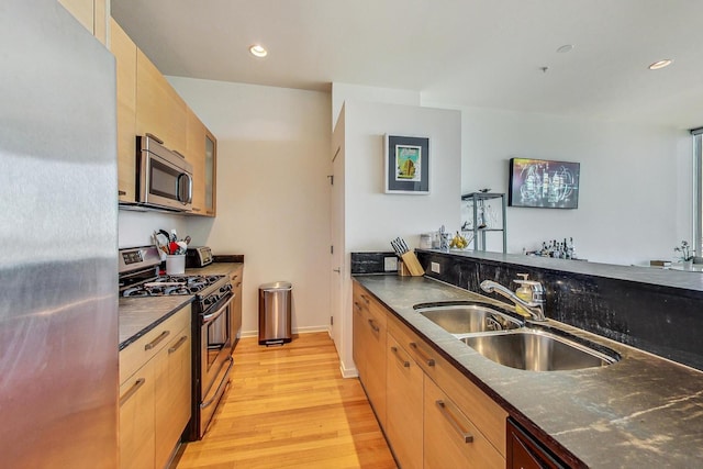 500 W Superior St Unit 1804, Chicago, IL 60654 - kitchen featuring appliances with stainless steel finishes, light wood-style flooring, dark stone counters, and recessed lighting
