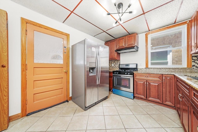 3545 W 62nd Pl, Chicago, IL 60629 - kitchen featuring stainless steel appliances, under cabinet range hood, backsplash, light stone countertops, and a drop ceiling