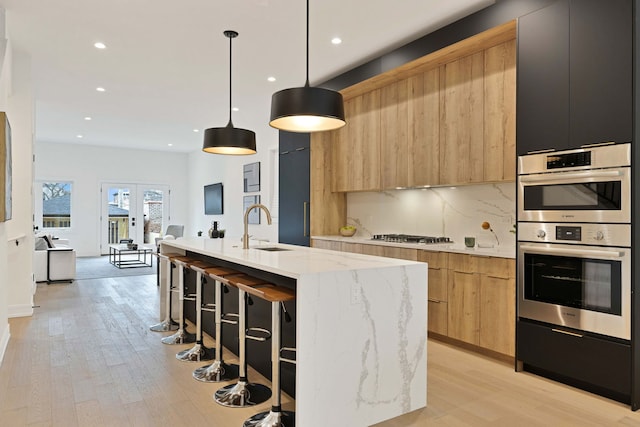 4932 S Martin Luther King Dr, Chicago, IL 60653 - kitchen featuring modern cabinets, a breakfast bar area, light wood finished floors, stainless steel appliances, and recessed lighting