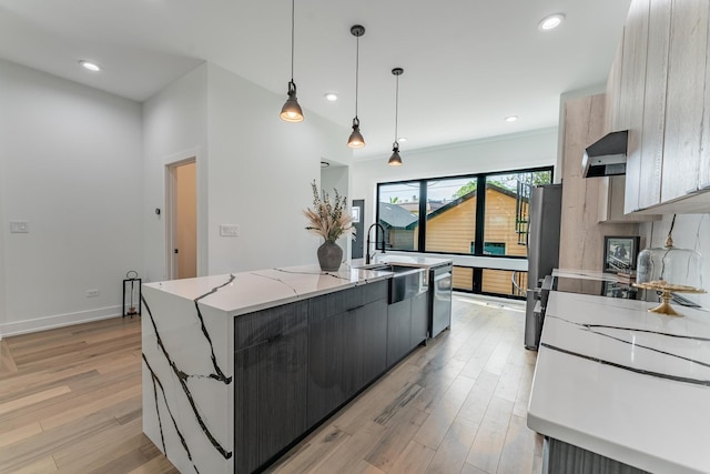 4210 W 5th Ave, Chicago, IL 60624 - kitchen with wall chimney exhaust hood, an island with sink, light wood-style flooring, light stone counters, and appliances with stainless steel finishes