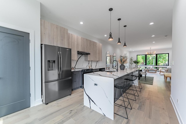 4210 W 5th Ave, Chicago, IL 60624 - kitchen with stainless steel fridge, modern cabinets, black electric range oven, a kitchen breakfast bar, and light stone counters