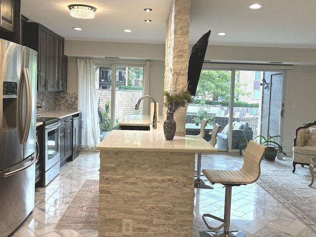 1103 S Hunt Club Dr Unit 125, Mount Prospect, IL 60056 - kitchen with appliances with stainless steel finishes, plenty of natural light, tasteful backsplash, recessed lighting, and light stone counters
