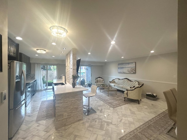 1103 S Hunt Club Dr Unit 125, Mount Prospect, IL 60056 - kitchen featuring stainless steel fridge with ice dispenser, light countertops, open floor plan, recessed lighting, and a breakfast bar area