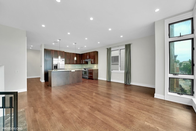 3321 N Sheffield Ave Unit 4, Chicago, IL 60657 - kitchen with appliances with stainless steel finishes, light countertops, a kitchen island, open floor plan, and tasteful backsplash
