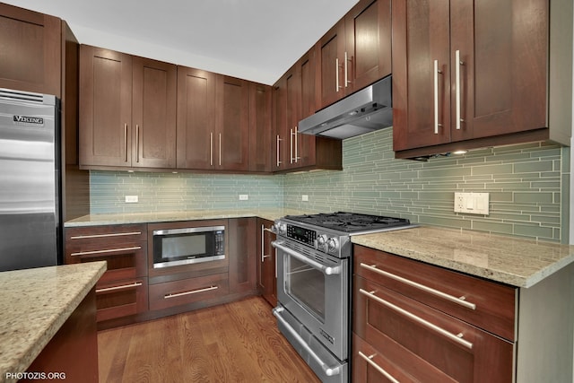3321 N Sheffield Ave Unit 4, Chicago, IL 60657 - kitchen with built in appliances, under cabinet range hood, light wood-type flooring, light stone counters, and decorative backsplash